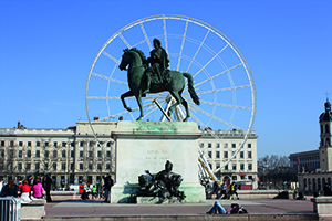 Vue sur la statue de Louis XIV sur son cheval au centre de la place et en arriere plan on peut apercevoir la grande roue à Lyon, place Bellecour